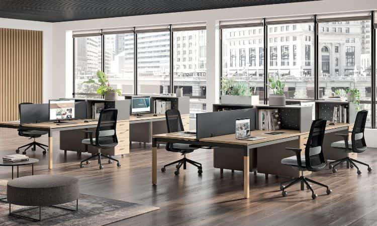 Open space haut de gamme avec bureaux et fauteuils devant des baies panoramiques