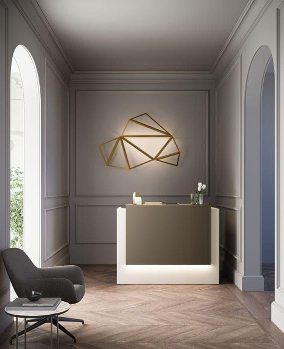 Banque d\'accueil blanche avec fauteuil et œuvre murale dorée, ambiance élégante