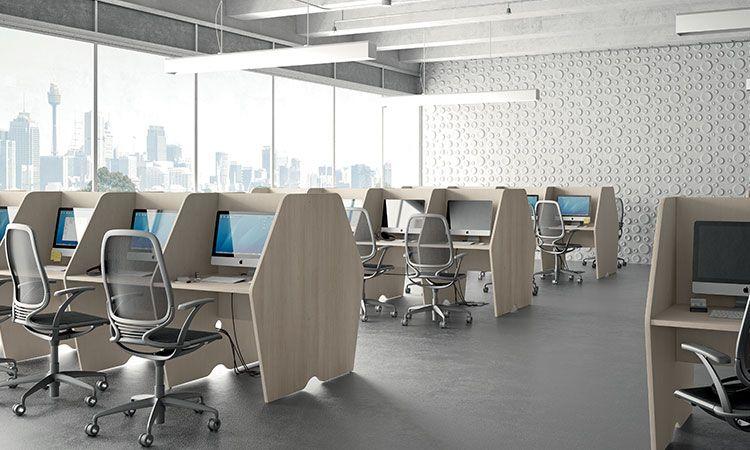 Call center équipé de postes avec écrans et fauteuils devant des baies vitrées