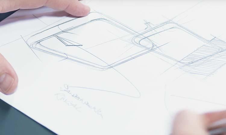 Main dessinant le croquis d\'un siège au crayon