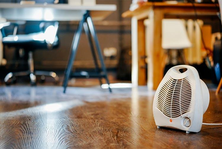 Chauffage d\'appoint posé au sol près d\'un bureau