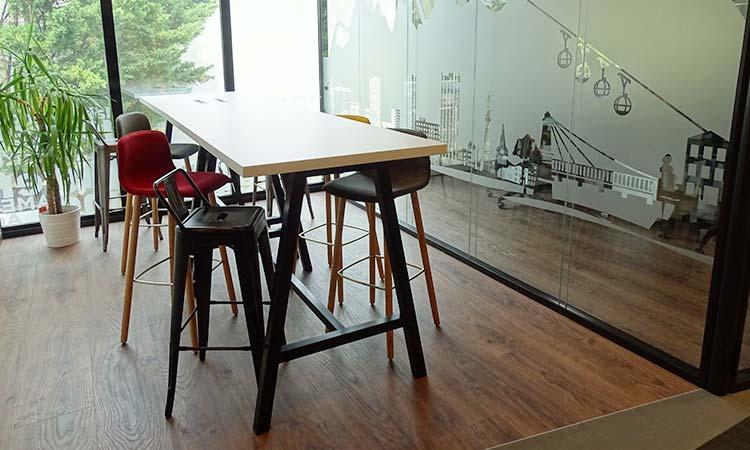 Table haute Erebus avec tabourets dans un espace lumineux