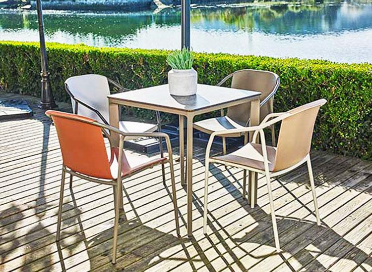 Terrasse extérieure avec table et chaises devant un plan d\'eau