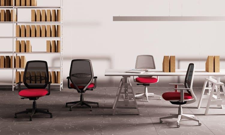 Sièges de bureau rouges et noirs à mécanisme synchrone autour d\'une table