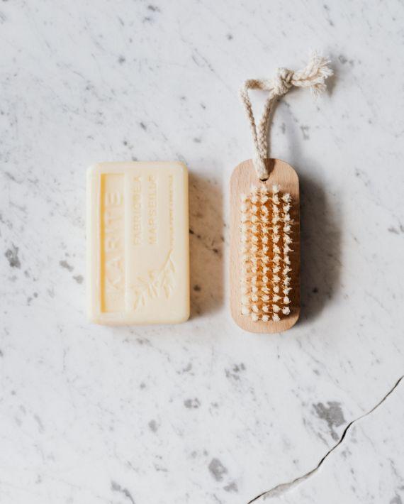 Brosse et savon en bois posés sur un plan de marbre