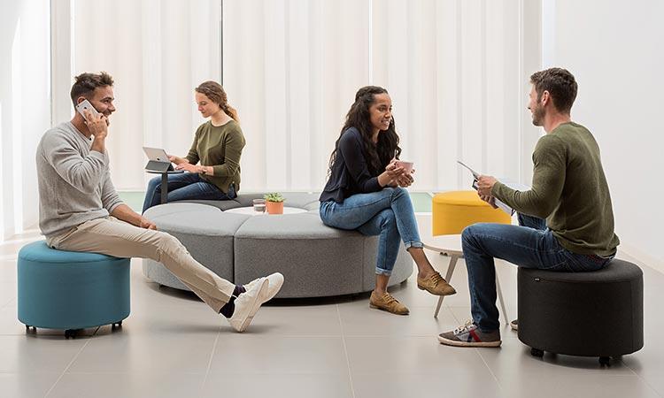 Groupe de personnes assises sur des poufs Comino en pleine discussion
