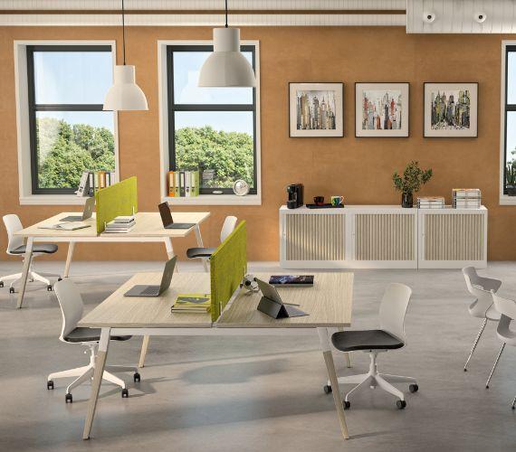 Open space chaleureux avec bureaux en bois et fauteuils verts