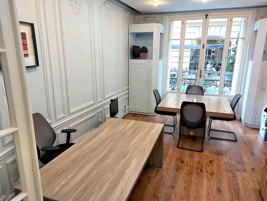 Bureau avec table en bois et fauteuils noirs, boiseries murales
