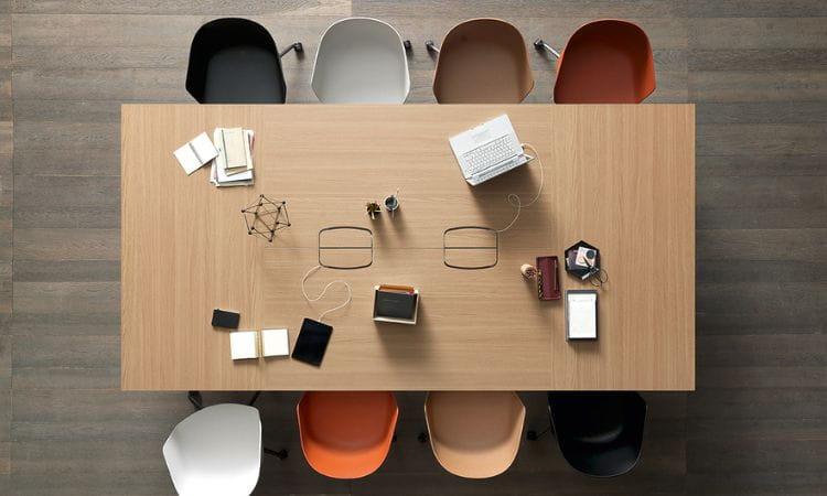 Table de réunion en bois équipée vue de dessus avec chaises colorées