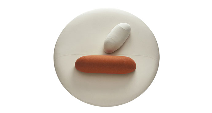 D&eacute;tail du canap&eacute; Inirida rond cr&egrave;me avec coussin bolster orange, vue de dessus