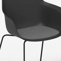 D&eacute;tail de l'assise de la chaise visiteur Ortega avec galette grise, coque noire, pi&eacute;tement luge